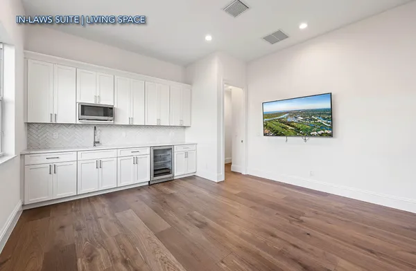a large white kitchen with a white stove top oven and white cabinets