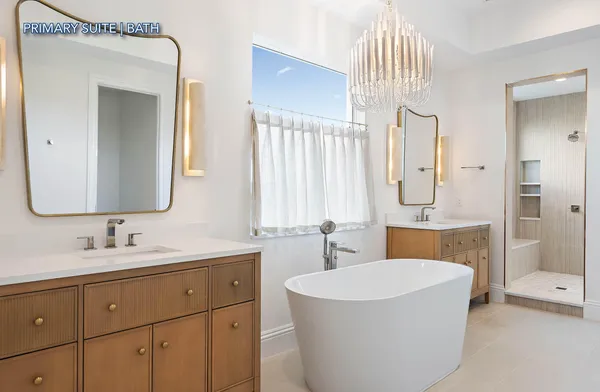 a bathroom with a double vanity sink mirror and bathtub
