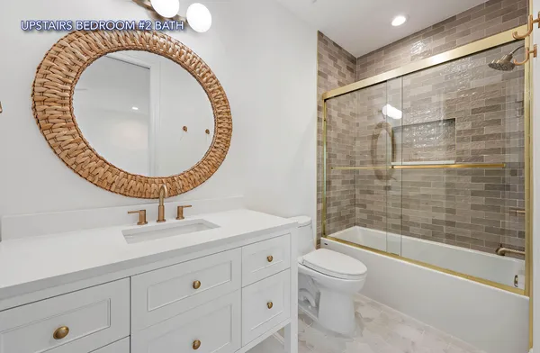 a bathroom with a sink a mirror a toilet and a shower
