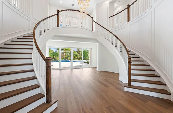 a view of staircase with wooden floor and white walls