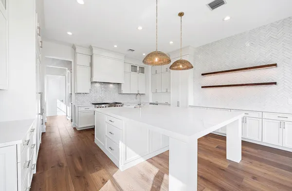 a kitchen with a refrigerator a sink and wooden floor