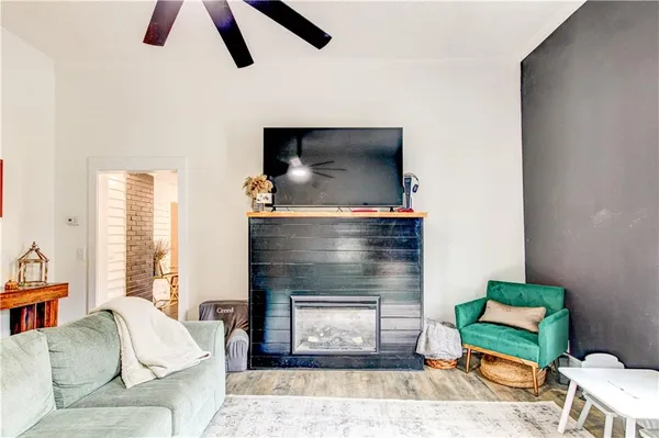 a living room with stainless steel appliances kitchen island granite countertop furniture wooden floor and a kitchen view