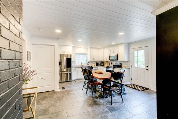 a kitchen with stainless steel appliances granite countertop a stove top oven a sink dishwasher and cabinets with wooden floor