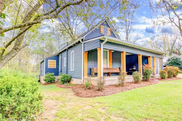 a front view of a house with swimming pool and porch with furniture
