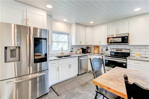 a large kitchen with kitchen island a white cabinets and wooden floor