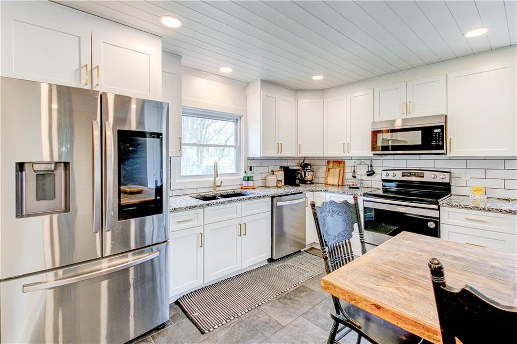 226 Mill Street Bowdon, GA 30108 - Photo 22 of 62 a kitchen with a refrigerator a stove a sink and chairs