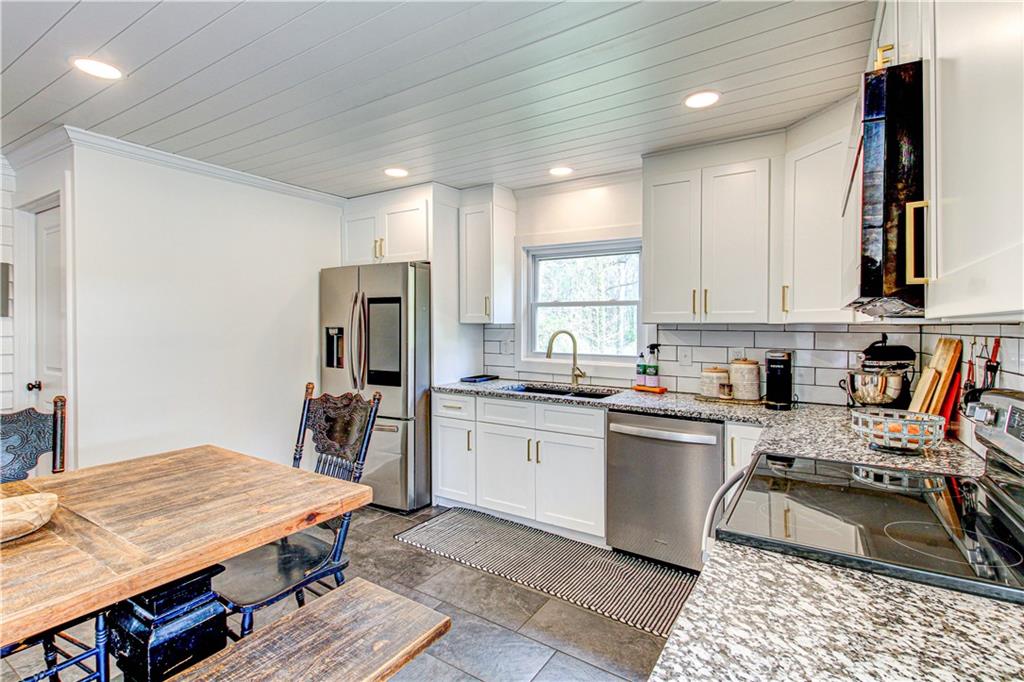 226 Mill Street Bowdon, GA 30108 - Photo 25 of 62 a kitchen with stainless steel appliances granite countertop a stove top oven a sink dishwasher and cabinets with wooden floor