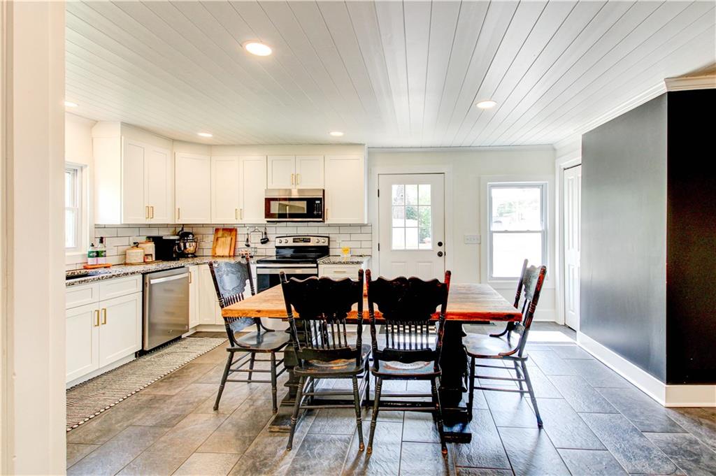 226 Mill Street Bowdon, GA 30108 - Photo 26 of 62 a kitchen with a dining table chairs and refrigerator