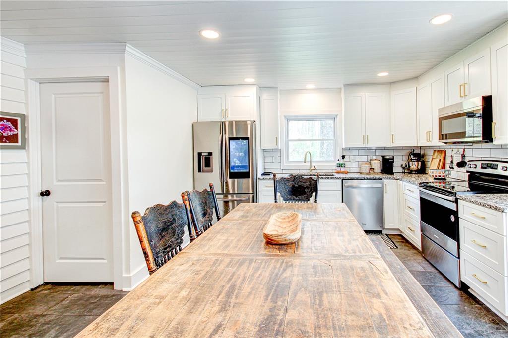 226 Mill Street Bowdon, GA 30108 - Photo 27 of 62 a large kitchen with kitchen island a white cabinets and wooden floor