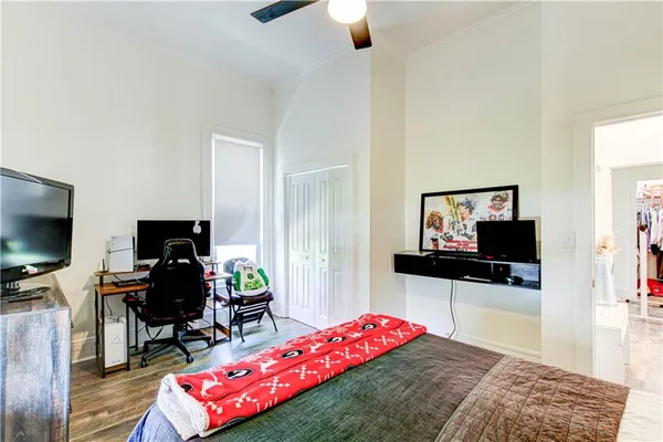 a bedroom with a bed and a flat tv screen on dresser