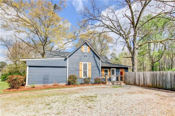 a front view of a house with a yard and wooden fence