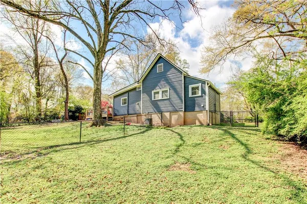 a view of a house with backyard and sitting area