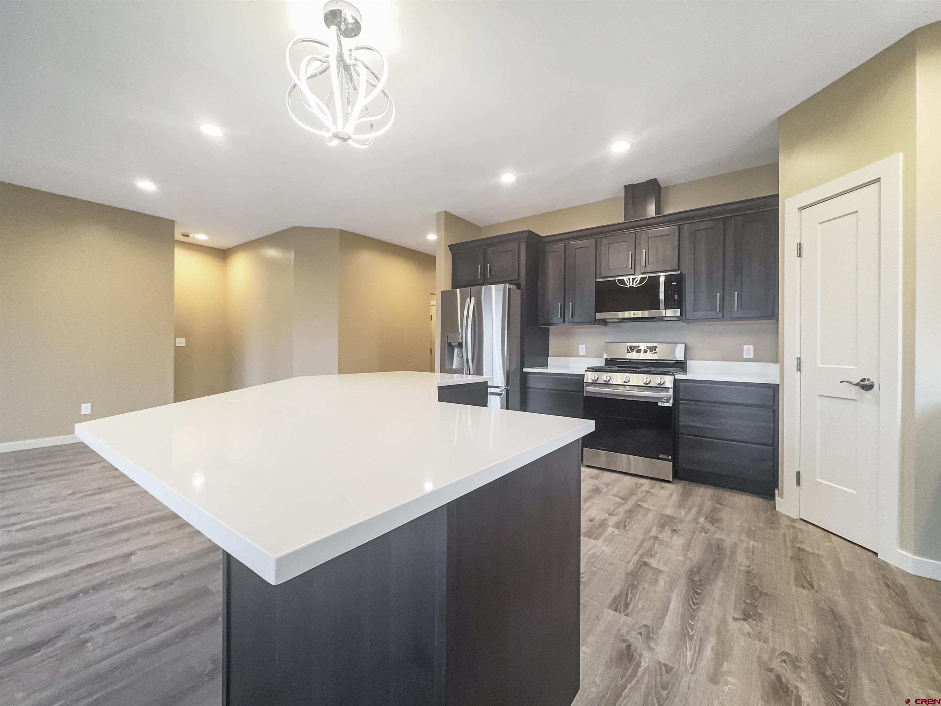 511 Juniper Place Cortez, CO 81321 - Photo 11 of 36 a kitchen with kitchen island a sink appliances and cabinets