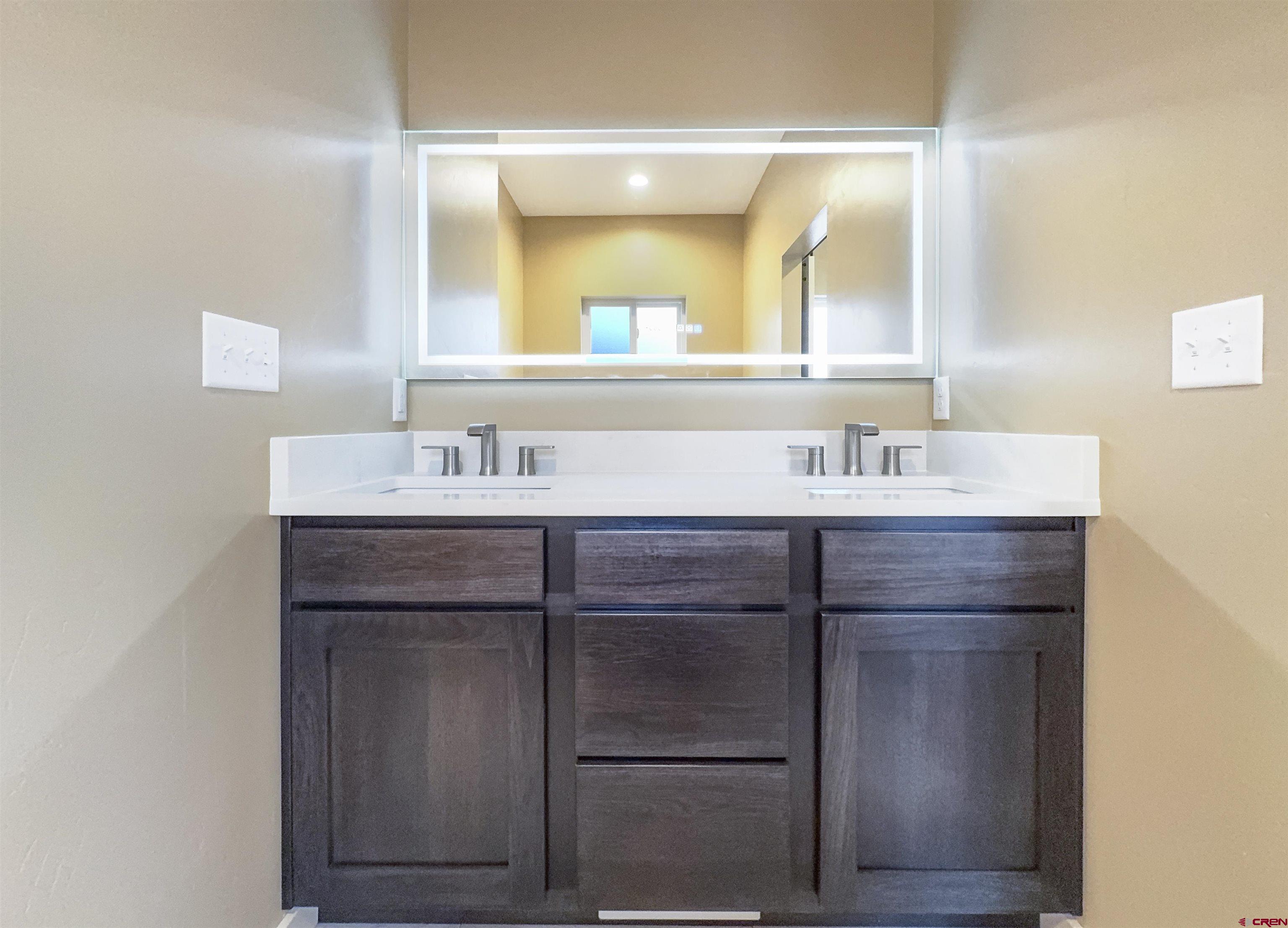 511 Juniper Place Cortez, CO 81321 - Photo 20 of 36 a bathroom with a sink vanity and mirror