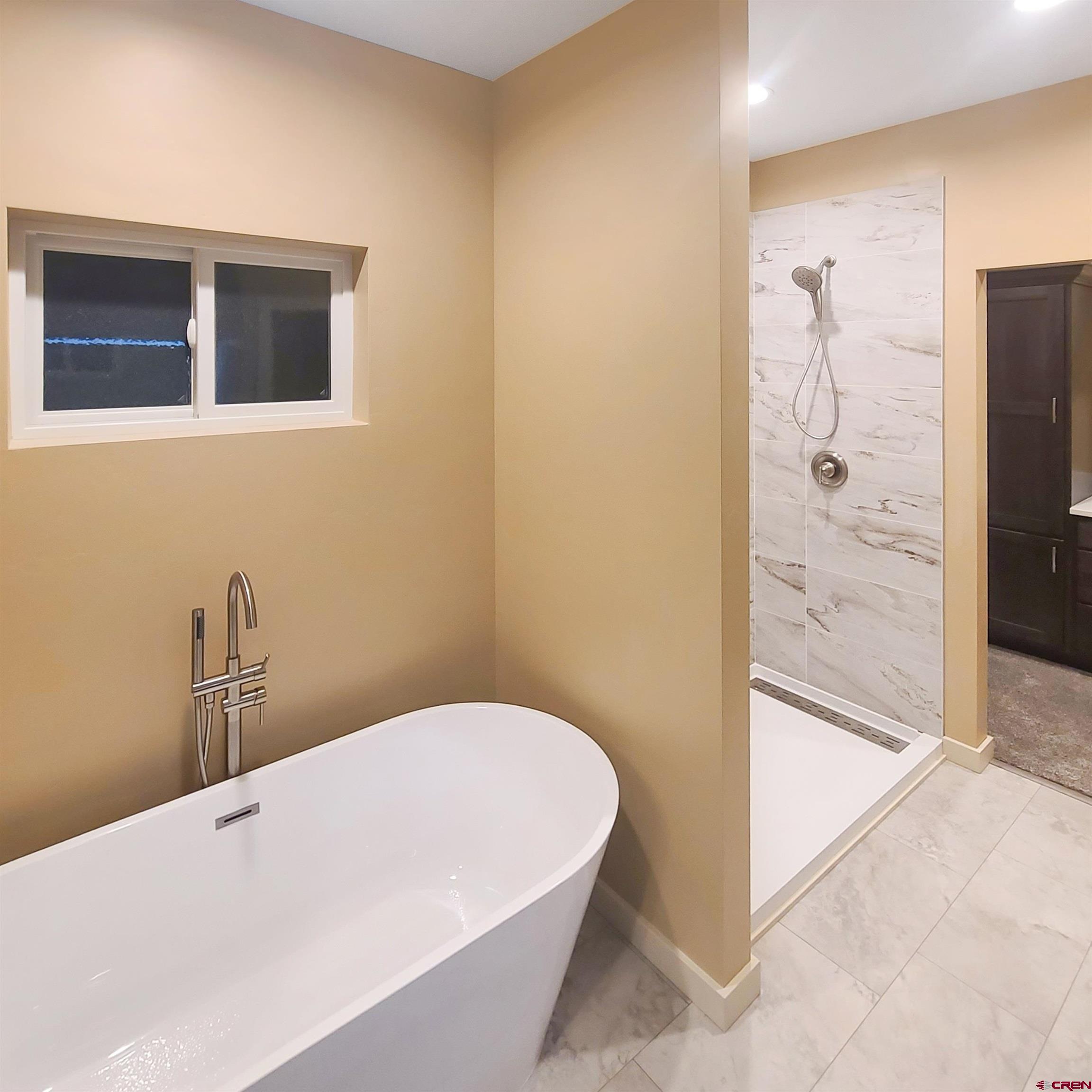 511 Juniper Place Cortez, CO 81321 - Photo 23 of 36 a bathroom with a bathtub and shower