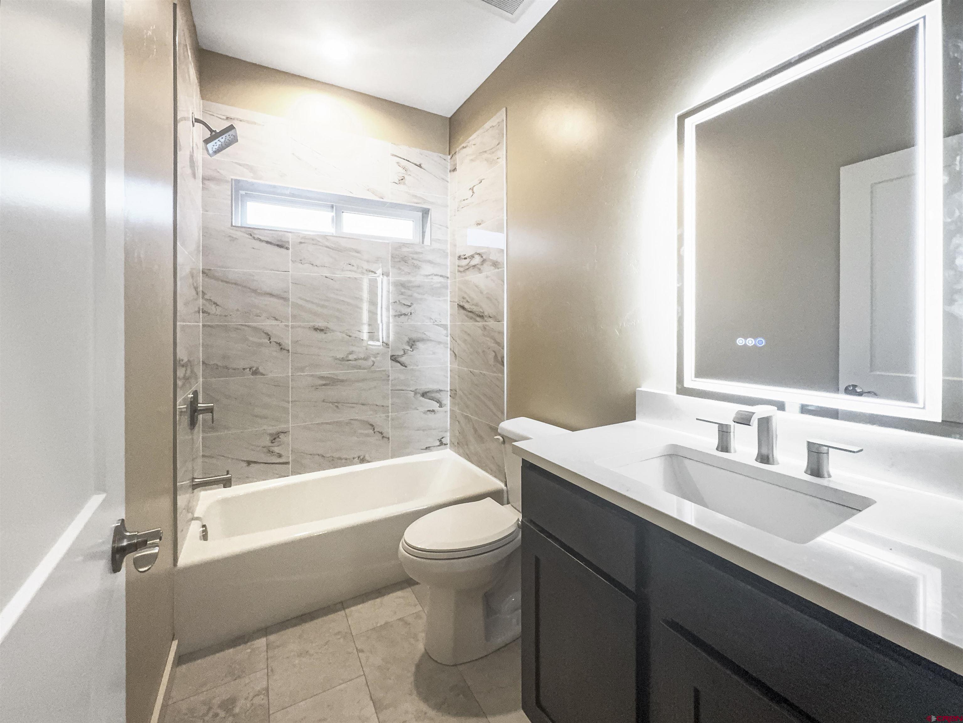 511 Juniper Place Cortez, CO 81321 - Photo 29 of 36 a bathroom with a bathtub shower sink vanity mirror and toilet