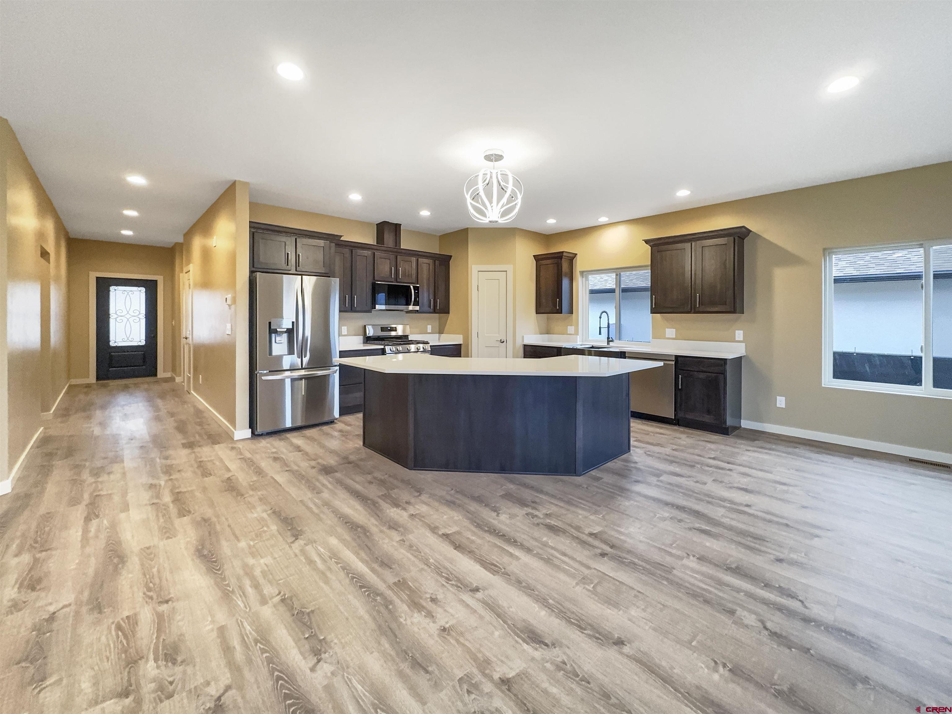 511 Juniper Place Cortez, CO 81321 - Photo 5 of 36 a large kitchen with stainless steel appliances kitchen island a large counter top a oven and a refrigerator