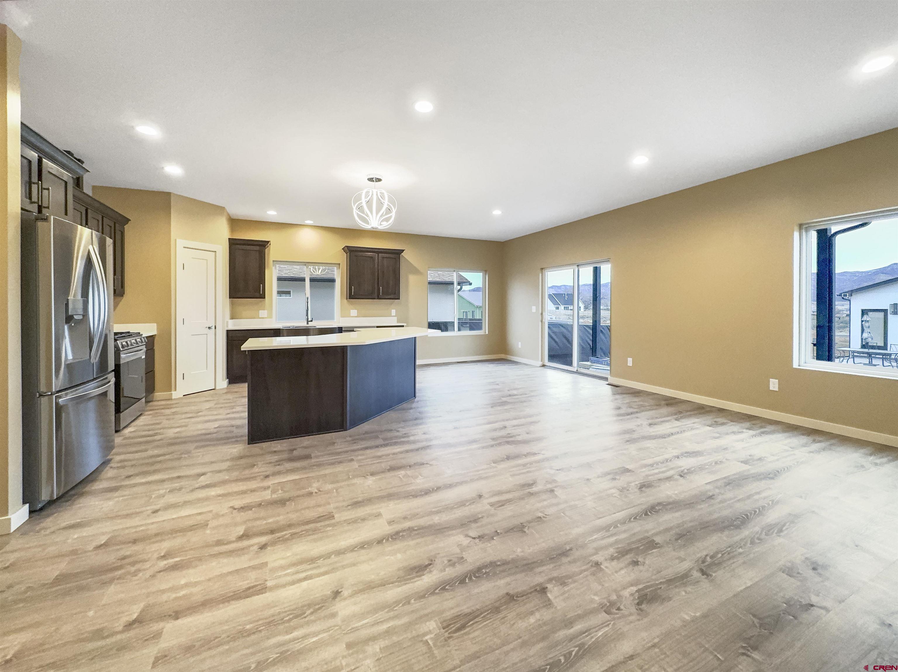511 Juniper Place Cortez, CO 81321 - Photo 6 of 36 a large kitchen with kitchen island a sink stainless steel appliances and cabinets