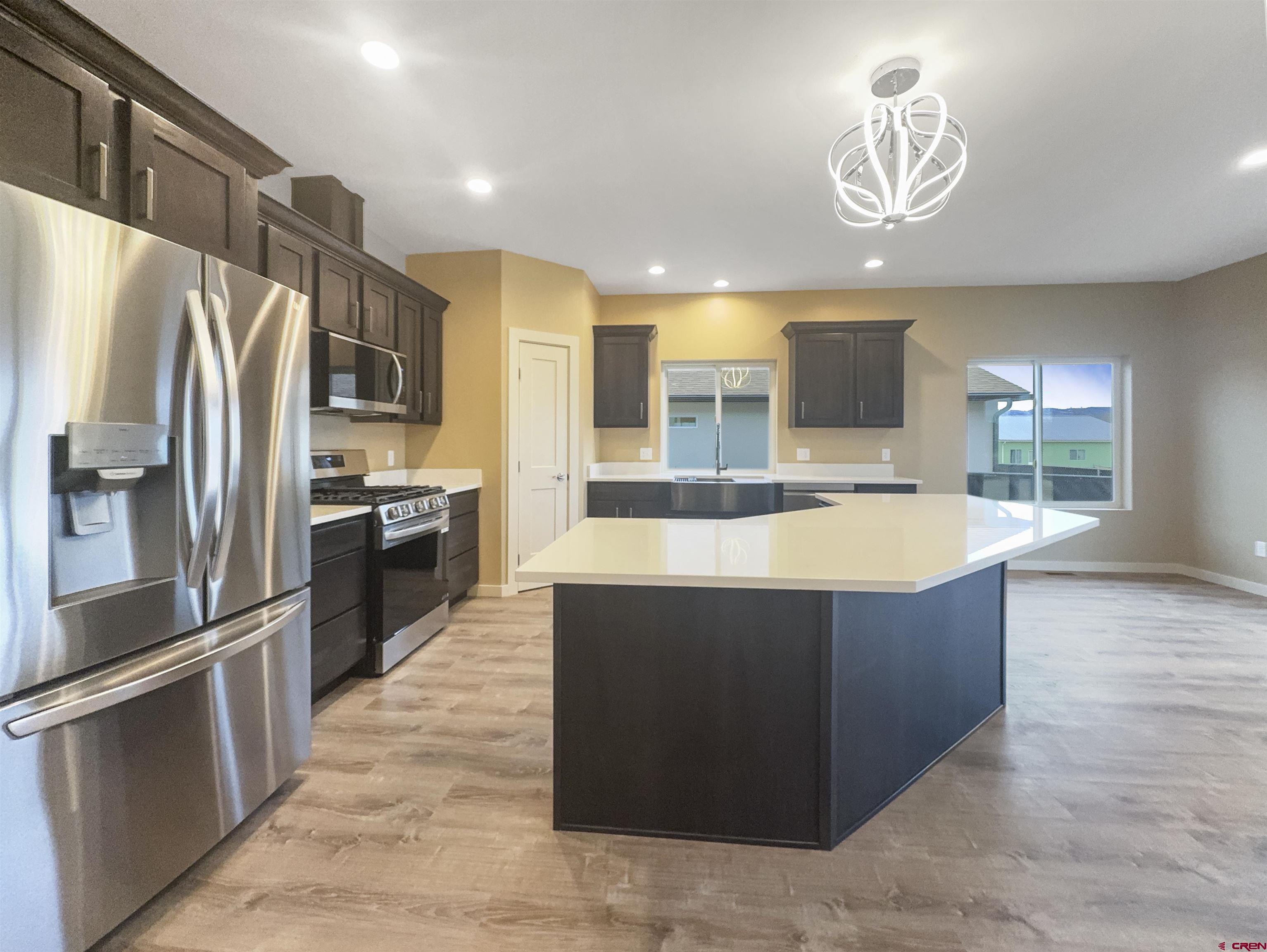 511 Juniper Place Cortez, CO 81321 - Photo 8 of 36 a large kitchen with stainless steel appliances wooden cabinets a stove and a refrigerator