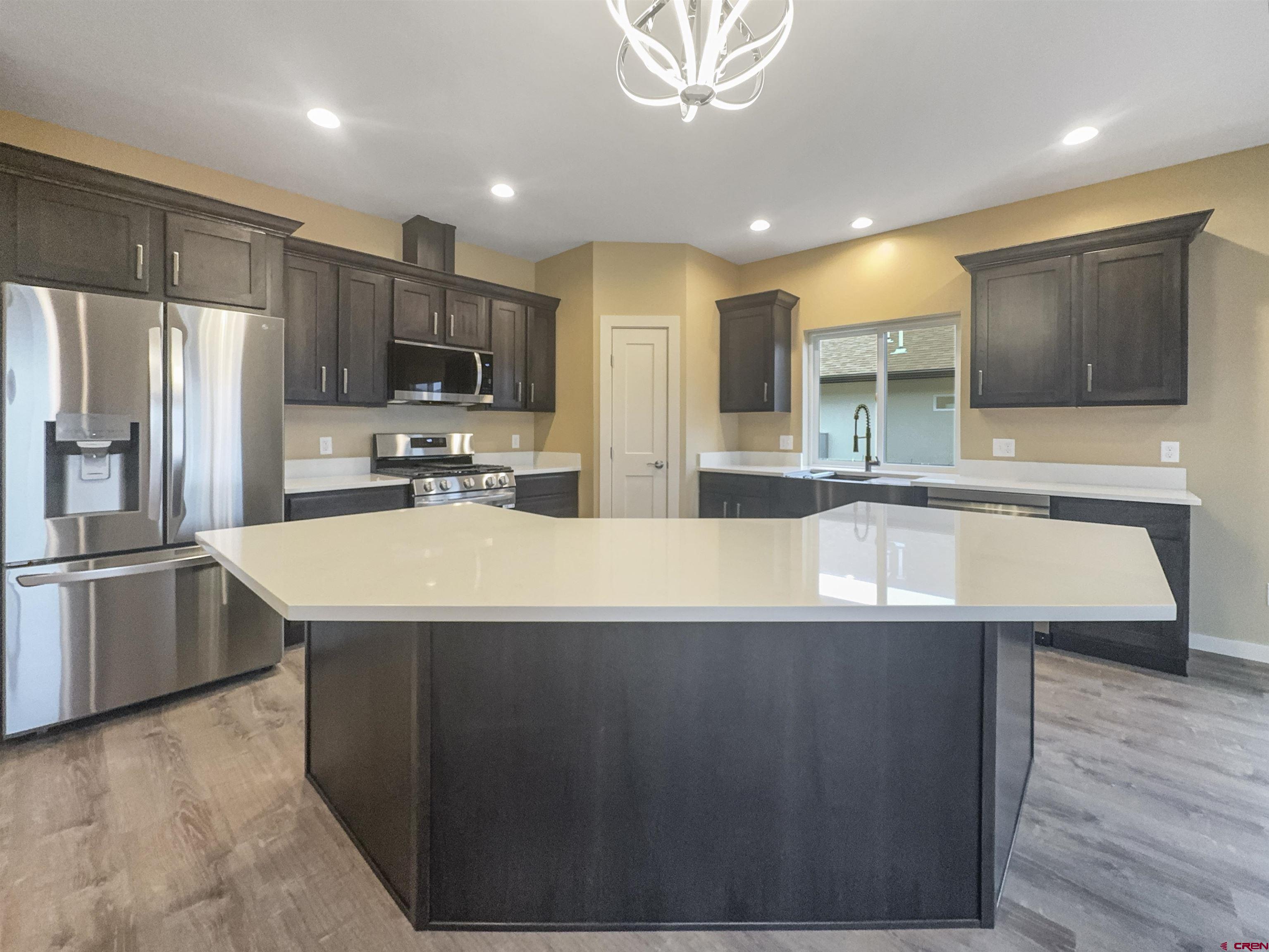 511 Juniper Place Cortez, CO 81321 - Photo 10 of 36 a large kitchen with kitchen island a sink stainless steel appliances and cabinets