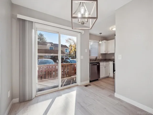 a open kitchen with granite countertop a refrigerator a stove a sink and a chandelier