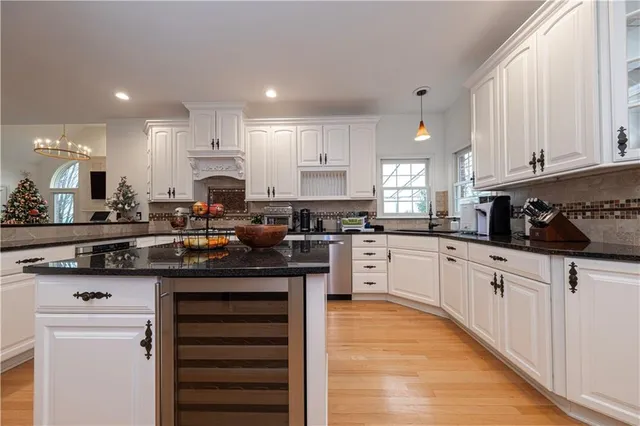 a kitchen with stainless steel appliances granite countertop a stove a sink and white cabinets