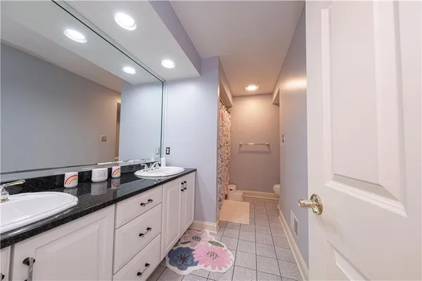 a spacious bathroom with a granite countertop sink a mirror and a shower
