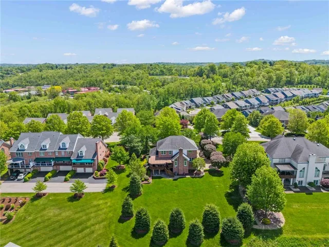 an aerial view of residential house with outdoor space and trees all around