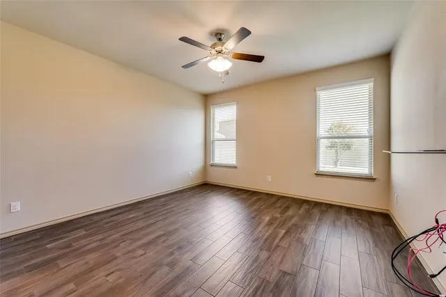 a view of wooden floor and a chandelier fan in a room