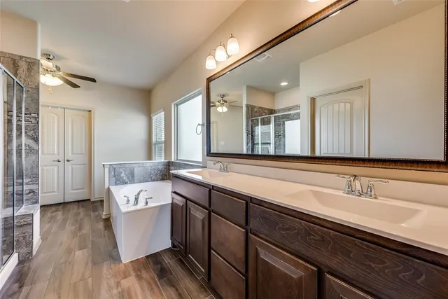 a spacious bathroom with a double vanity sink a mirror and a bathtub