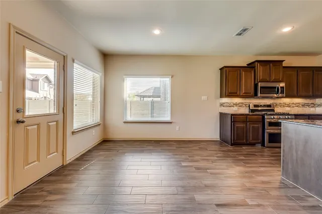a kitchen with stainless steel appliances granite countertop a stove a sink and a refrigerator