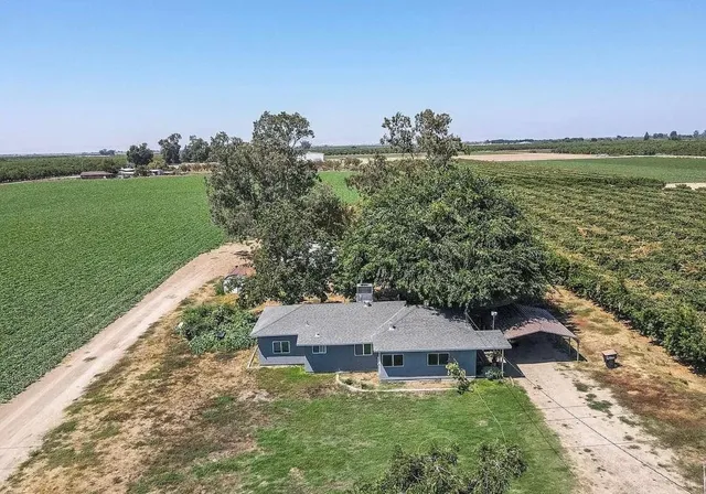 an aerial view of a house with a garden and lake view