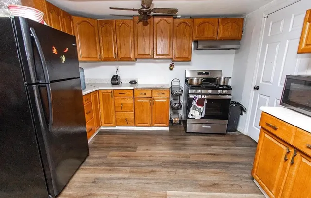 a kitchen with stainless steel appliances granite countertop a refrigerator a stove and a sink