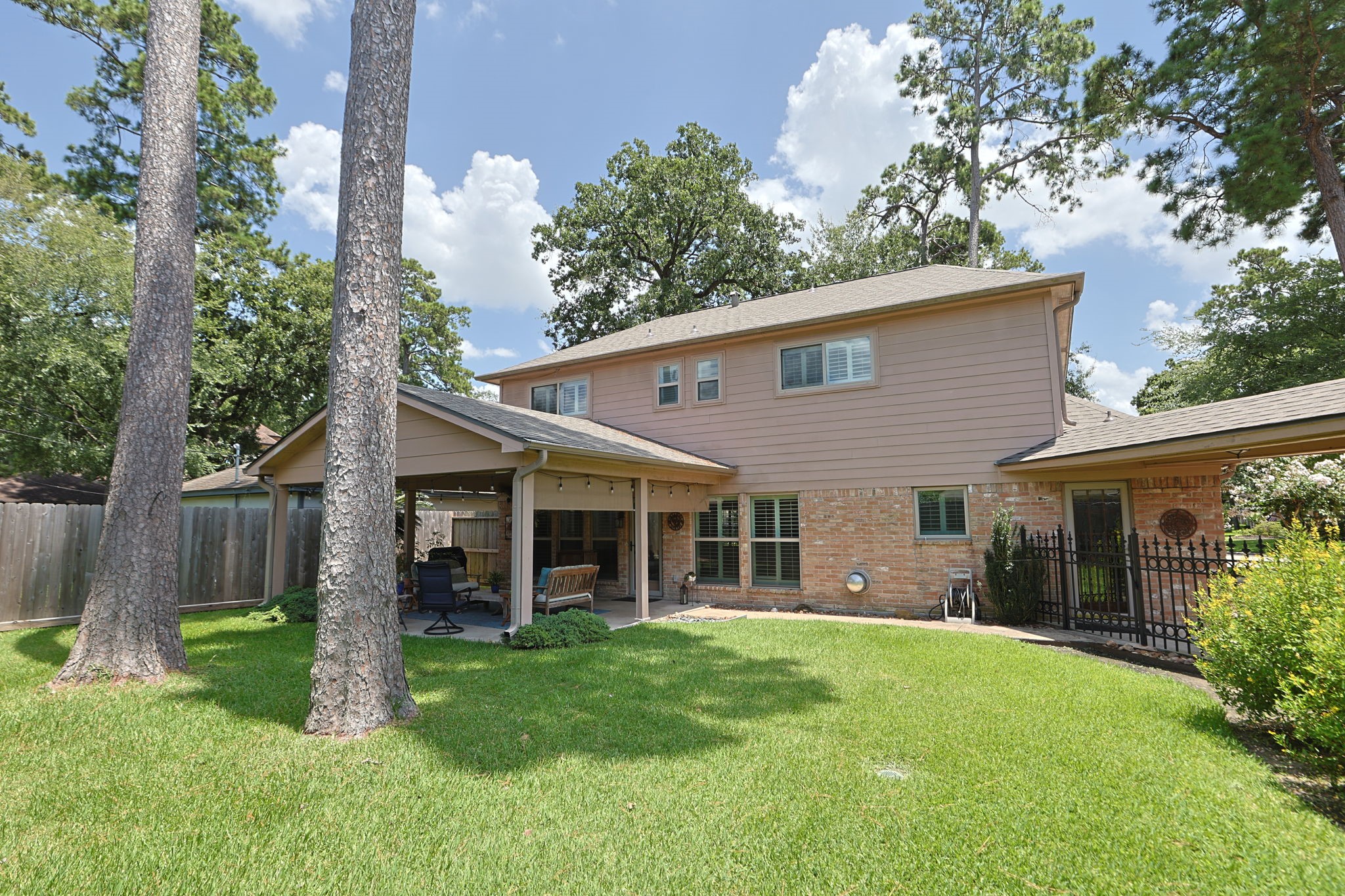 3414 Flaming Candle Drive Spring, TX 77388 - Photo 45 of 50 BACK YARD - The wrought iron fence between the garage and house was recently painted. New post installed 2026.