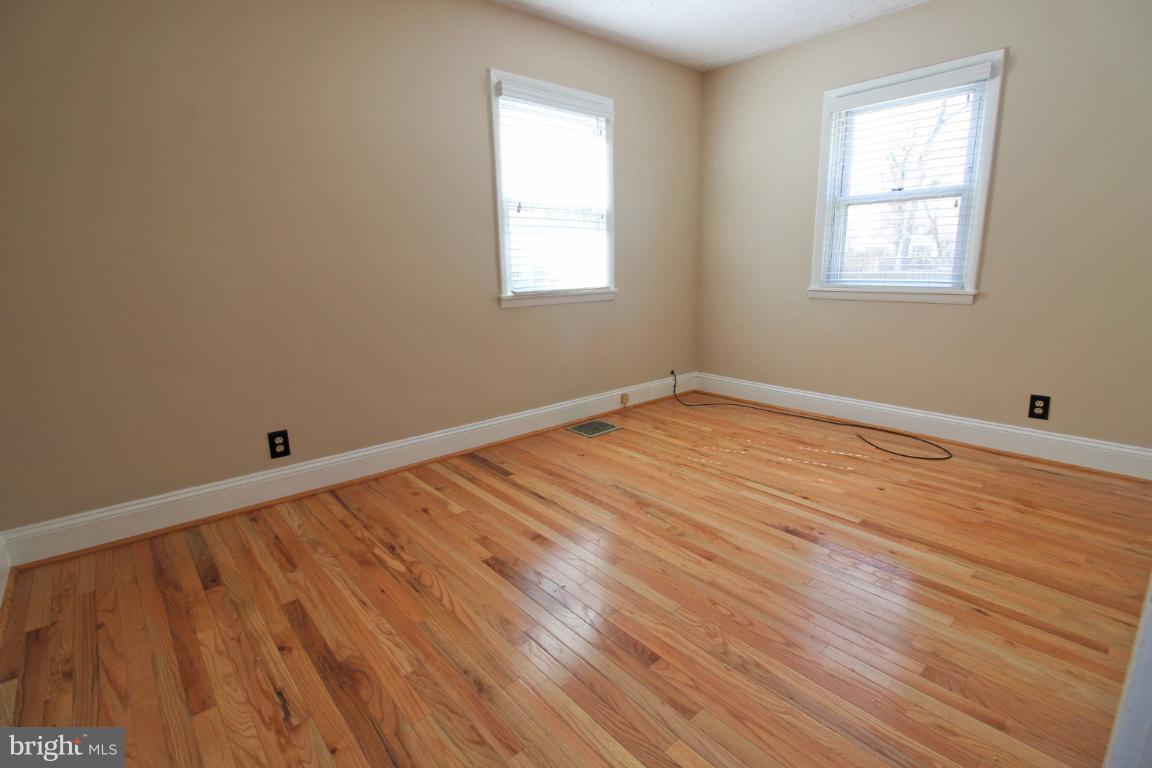 24 Hampton Road Linthicum Heights, MD 21090 - Photo 13 of 23 a view of an empty room with wooden floor and a window