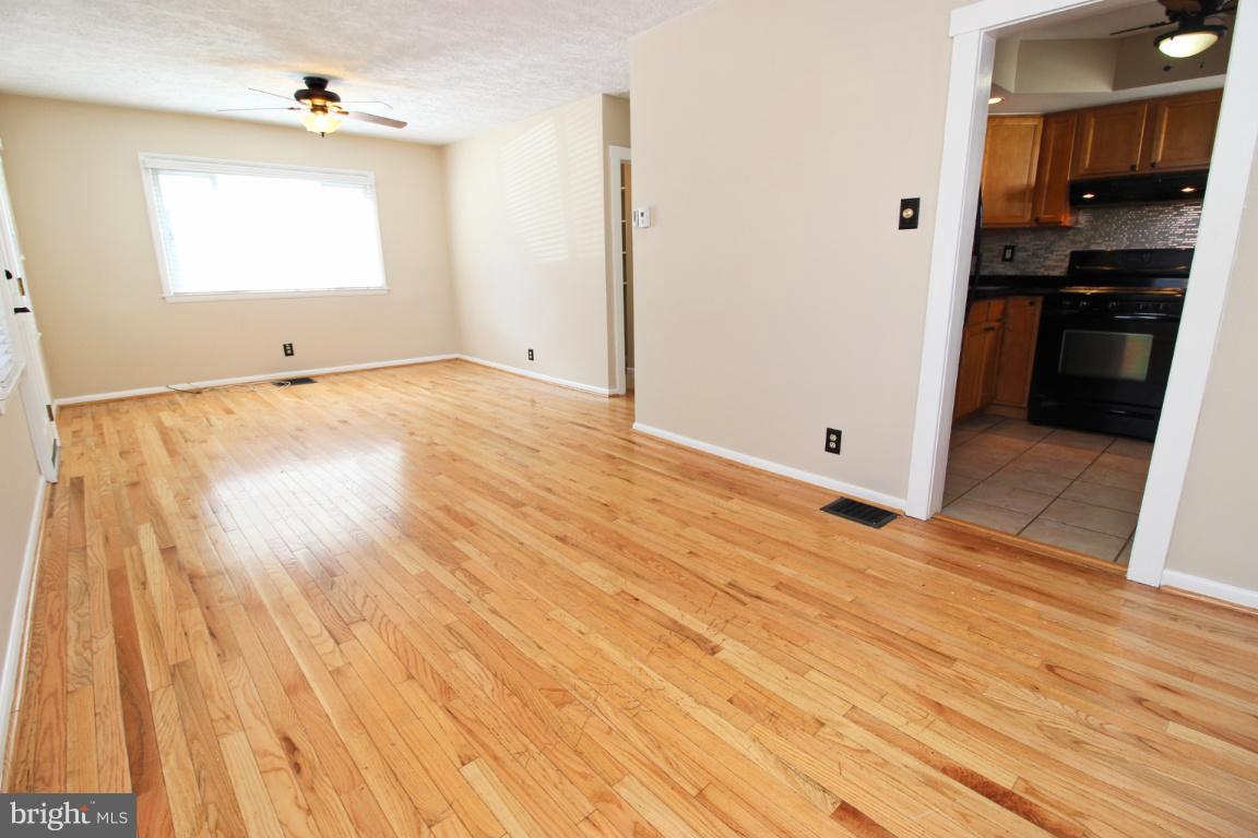 24 Hampton Road Linthicum Heights, MD 21090 - Photo 5 of 23 an empty room with wooden floor kitchen view and a window