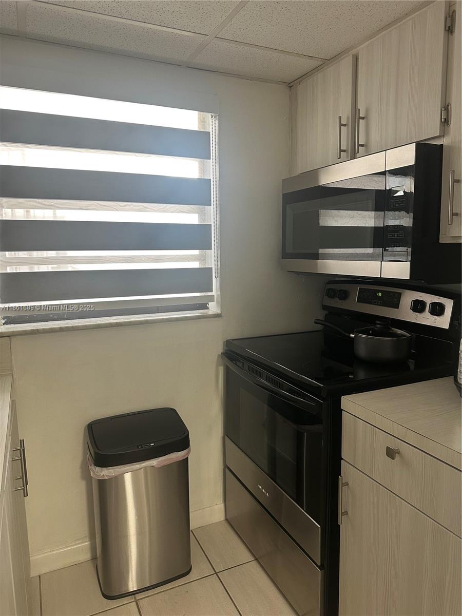 1335 West 68th Street, Unit 308 Hialeah, FL 33014 - Photo 6 of 18 a kitchen with a stove and a microwave