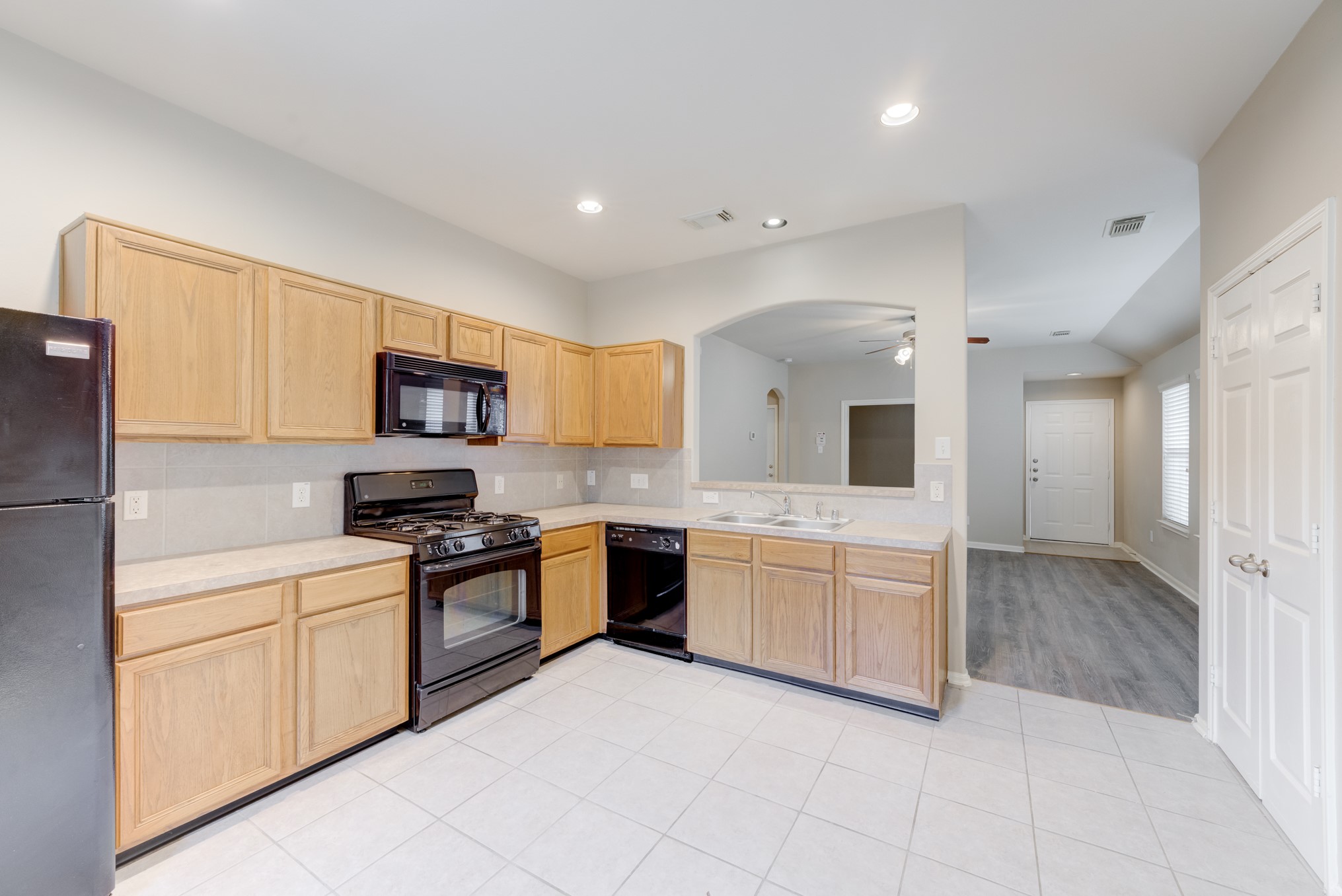 6839 Tammany Manor Lane Spring, TX 77379 - Photo 10 of 25 Views between the kitchen and living room, noticing recessed lighting and the arched detail