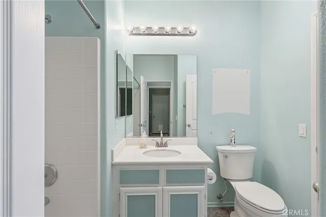 a bathroom with a toilet a sink and mirror