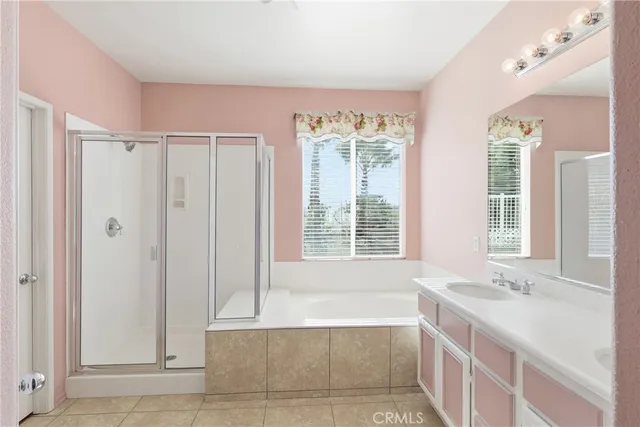 a spacious bathroom with a tub sink and mirror