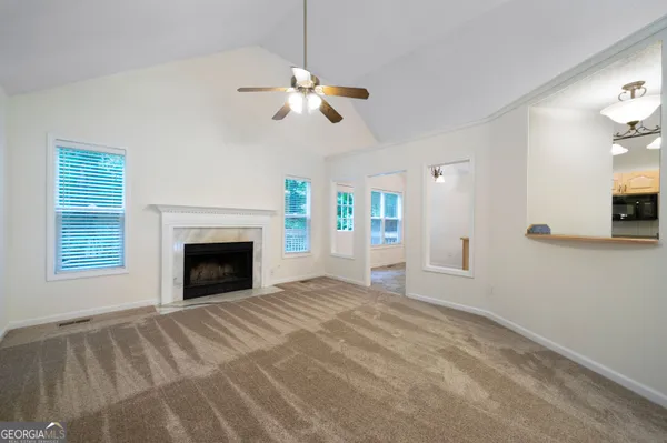 a view of an empty room with window and fireplace