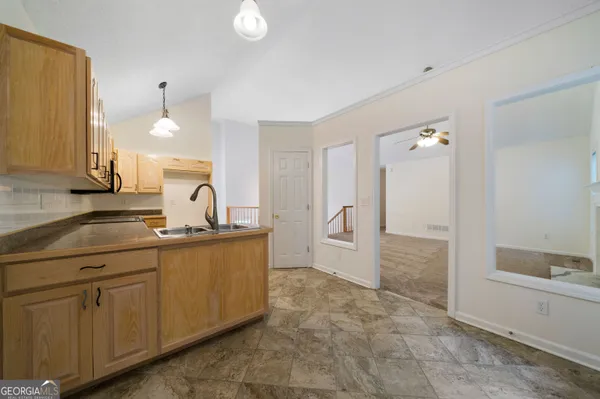 a spacious bathroom with a granite countertop sink a toilet a mirror and shower