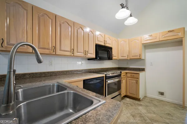 a kitchen with a sink cabinets and stainless steel appliances