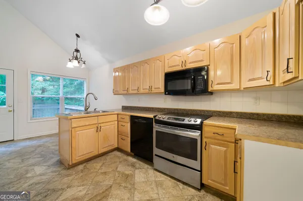 a kitchen with stainless steel appliances granite countertop a stove a sink and a microwave