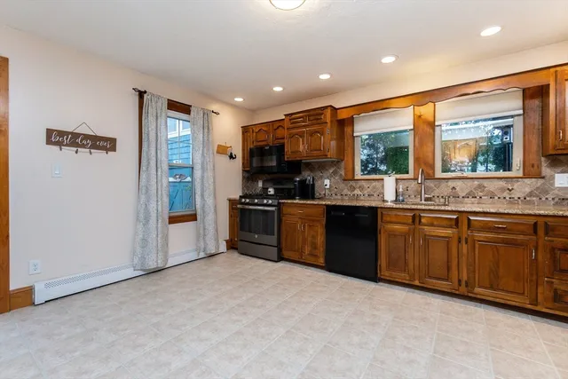 a large kitchen with stainless steel appliances granite countertop a refrigerator and a stove top oven
