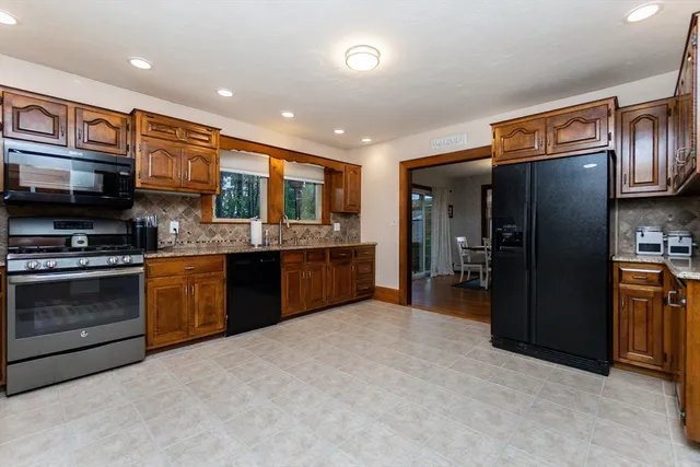 a kitchen with stainless steel appliances granite countertop a refrigerator and a stove top oven