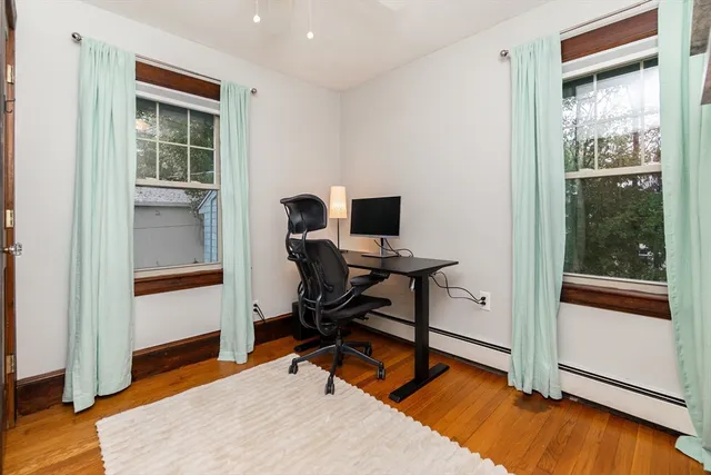 a view of a workspace with wooden floor and a window