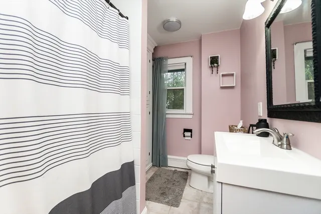 a bathroom with a sink a toilet and shower curtain