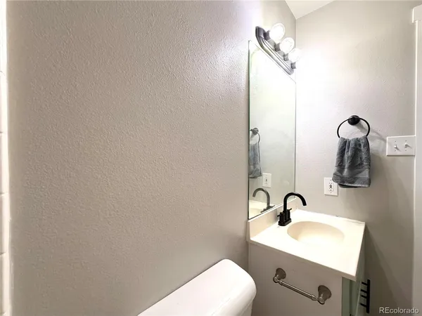 a bathroom with a toilet a sink and mirror