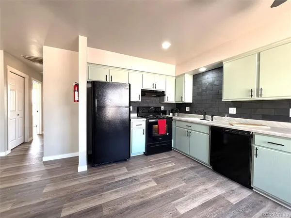 a kitchen with a refrigerator sink and cabinets